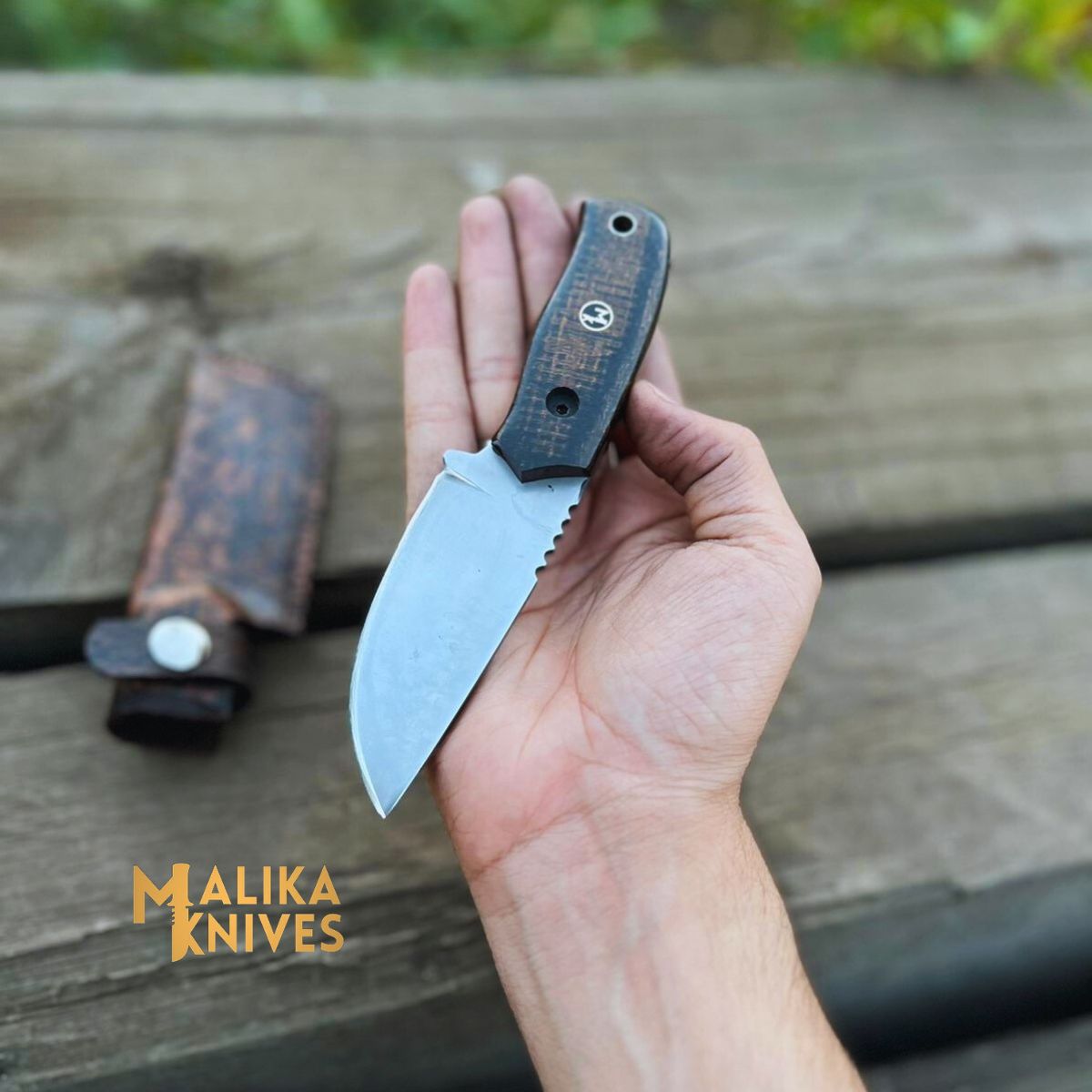 A close-up image of a Straight-Back EDC Knife by Malika Knives. The knife features a sleek and sturdy design with a straight blade, ergonomic handle, and a textured grip for optimal control. The blade is made of high-quality steel and showcases impeccable craftsmanship. The knife is showcased against a neutral background, highlighting its fine details and the brand's logo engraved on the handle."